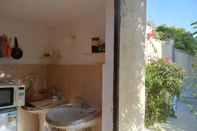 a kitchen with a sink and a microwave at Our Villa's Pine Cottage - HQ Budget Stay - Wonderful horizon view of Jerash in Jerash