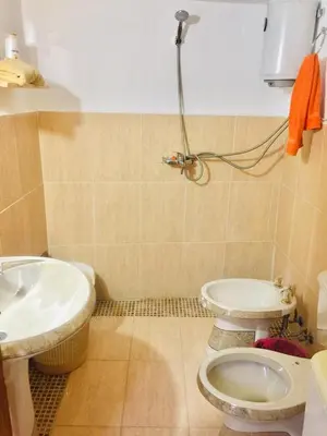 a bathroom with two toilets and a sink at Our Villa's Pine Cottage - HQ Budget Stay - Wonderful horizon view of Jerash in Jerash