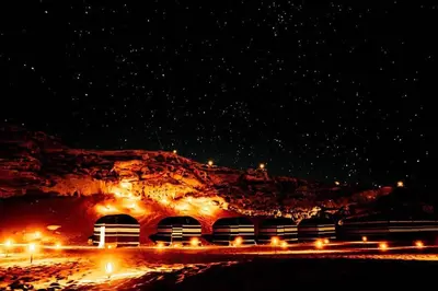 a train station at night with a mountain at Candle light camp & tours in Wadi Rum