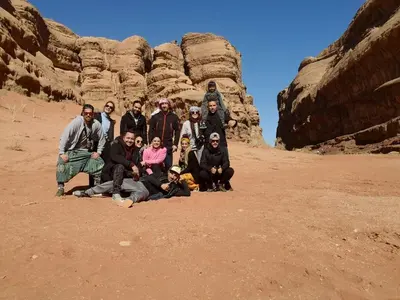 a group of people posing for a picture in the desert at Candle light camp & tours in Wadi Rum