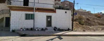 a white brick building with a door on a street at Idris home in Wadi Musa