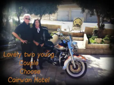 a man and a woman sitting next to a motorcycle at Cairwan Hotel in Kerak