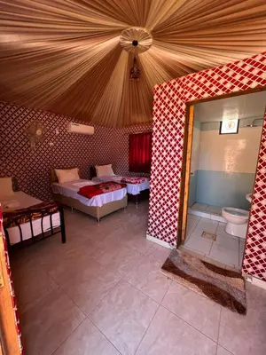 a large room with two beds and a toilet at Sand Star Camp in Wadi Rum