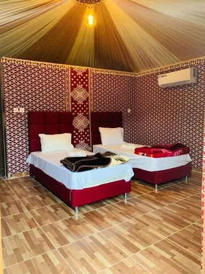 two beds are in a room with a wall at Sand Star Camp in Wadi Rum