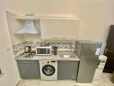 a small kitchen with a sink and a microwave at Villa Mira Guesthouse 1 - Downtown Central Amman - AL DIYRIH in Amman