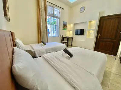 a hotel room with two beds and a tv at Villa Mira Guesthouse 1 - Downtown Central Amman - AL DIYRIH in Amman
