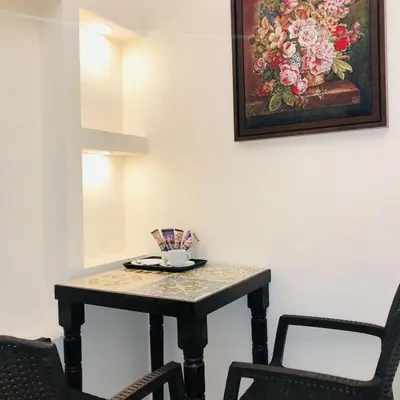 a table and two chairs in a room with a painting at Villa Mira Guesthouse 1 - Downtown Central Amman - AL DIYRIH in Amman