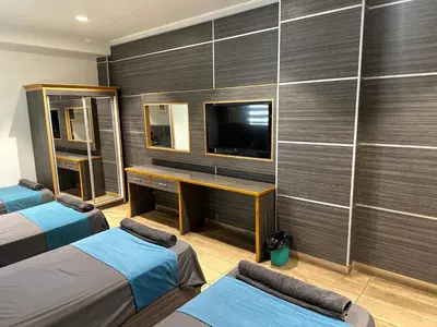 a hotel room with two beds and a television at ArwaHotel Apartments اروى للشقق الفندقية in Aqaba