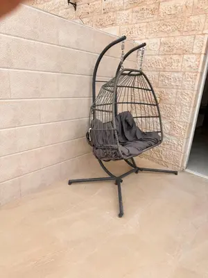 a black bird cage sitting next to a brick wall at ArwaHotel Apartments اروى للشقق الفندقية in Aqaba