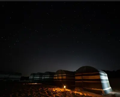 a group of domes on the beach at night at Desert shine camp in Wadi Rum
