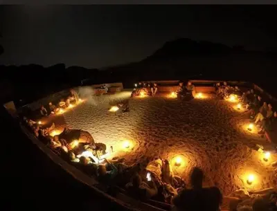 a group of people sitting in a circle with lights at Desert shine camp in Wadi Rum