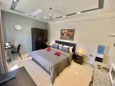a bedroom with a bed with two red pillows at Villa Mira GuestHouse 2 - Downtown Central Amman - AL DIYRIH in Amman