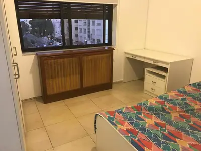 a bedroom with a bed and a desk and a window at Nice Furnished apartment in Amman