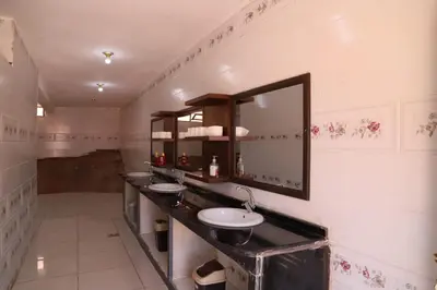 a bathroom with three sinks and a mirror at Desert Bedouin camp in Wadi Rum