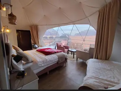 a bedroom with a tent with a view of the desert at Faisal Wadi Rum Camp in Wadi Rum