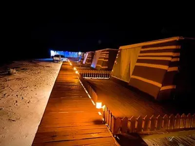 a row of benches on a beach at night at Discover the life of Wadi Rum camp in Wadi Rum