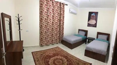 a small room with two beds and a rug at Rakan ApartHotel and Luxury Rooms in Wadi Musa