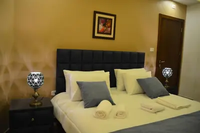 a bedroom with a large bed with white sheets and pillows at سما عمان للشقق الفندقية Sama Amman Hotel Apartments in Amman
