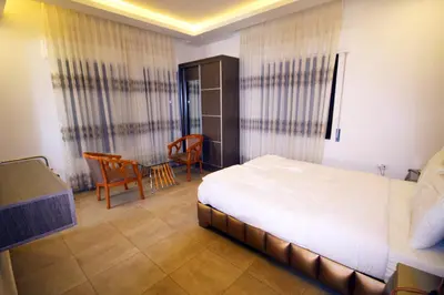 a bedroom with a bed and a table and a chair at سما عمان للشقق الفندقية Sama Amman Hotel Apartments in Amman