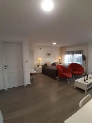 a bedroom with a bed and two red chairs at The Place in Madaba