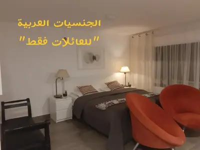 a bedroom with a bed and a red chair at The Place in Madaba