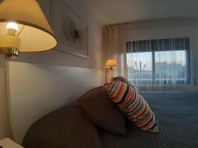 a bedroom with a bed with a lamp and a window at The Place in Madaba