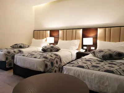 a hotel room with two beds and a table at Petra Heart Hotel in Wadi Musa