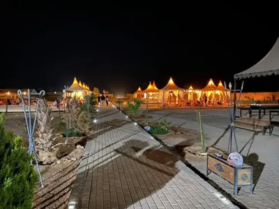 a group of tents with lights in a courtyard at night at Al Sultana Luxury Camp in Wadi Rum