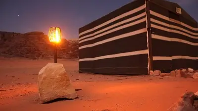 a flag and a rock in the desert at night at Quite bedouin life in Wadi Rum