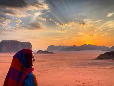 a woman standing in the desert watching the sunset at Quite bedouin life in Wadi Rum