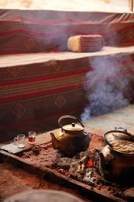 two tea pots sitting on a stove with smoke at Quite bedouin life in Wadi Rum