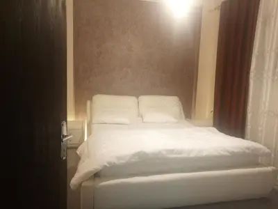 a bed with white sheets and pillows in a room at Jarajreh Apartments/ Hotel in Kerak