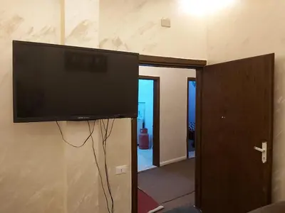 a flat screen tv on a wall in a living room at Jarajreh Apartments/ Hotel in Kerak
