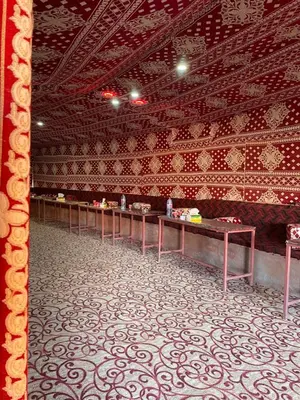a room with a long row of tables in a building at Walid Bedouin Camp in Wadi Rum