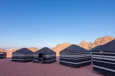 a row of black tents in the desert at Wadi rum desert breath in Wadi Rum