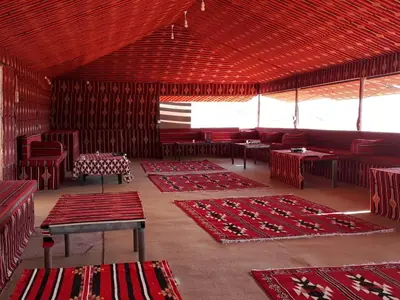 a room with red tables and chairs and red carpets at Wadi rum desert breath in Wadi Rum