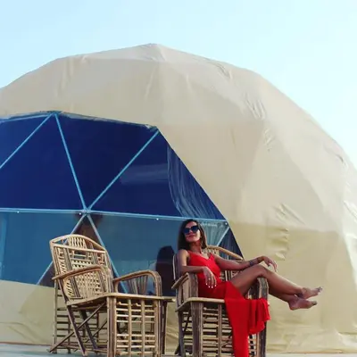 a woman in a red dress sitting in a tent at Rum warm bubble camp in Wadi Rum