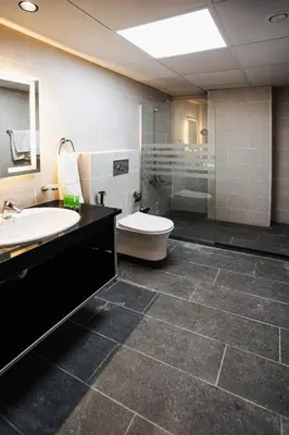 a bathroom with a toilet and a sink and a shower at Diamond Hotel in Amman