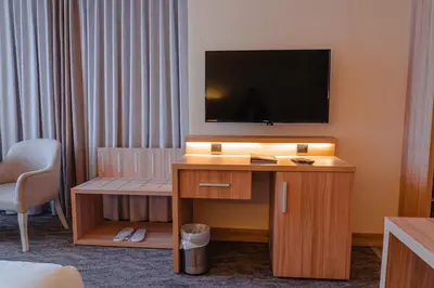 a hotel room with a television and a desk with a chair at La Casa Hotel Amman by FHM in Amman