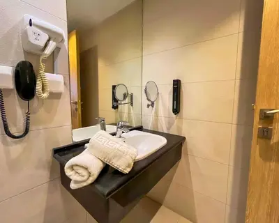 a bathroom with a sink and a phone at La Casa Hotel Amman by FHM in Amman