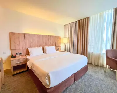 a hotel room with a large bed and a large window at La Casa Hotel Amman by FHM in Amman