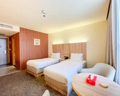 a hotel room with two beds and a table at La Casa Hotel Amman by FHM in Amman