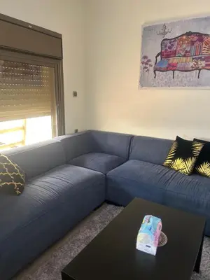 a blue couch in a living room with a table at The Pearl of Jerash in Jerash