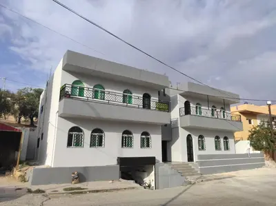 a white building with a balcony on top of it at Oskar Appartment 2 in Wadi Musa