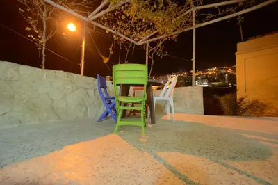 two green and blue chairs sitting on a patio at night at Petra Lion Hotel in Wadi Musa