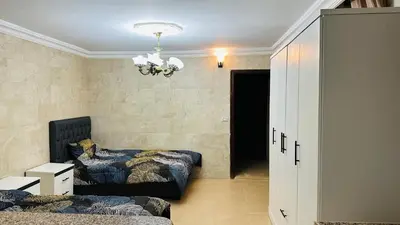 a bedroom with two beds and a chandelier at شقق الياسمين in Jerash