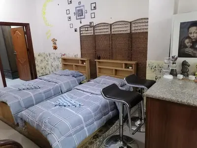 a bedroom with two beds and two bar stools at Jasmine's House in Jerash