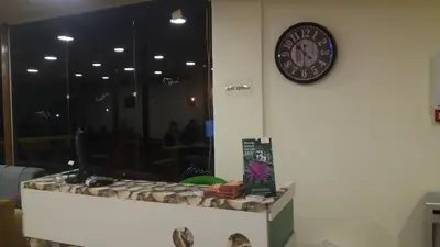 a clock hanging on a wall next to a counter at PETRA Cabin Dorms Hostel in Wadi Musa