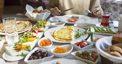 a table topped with plates of food and bowls of food at PETRA Cabin Dorms Hostel in Wadi Musa