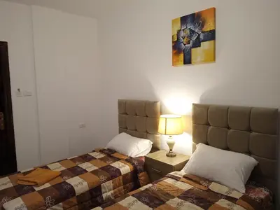 a bedroom with two beds and a lamp on a table at Petra Planet in Wadi Musa